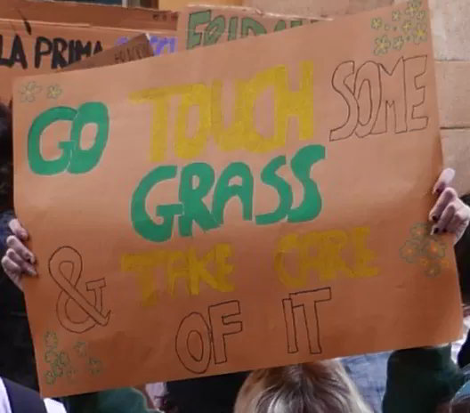 Cartello: "Go touch some grass & take care of it"